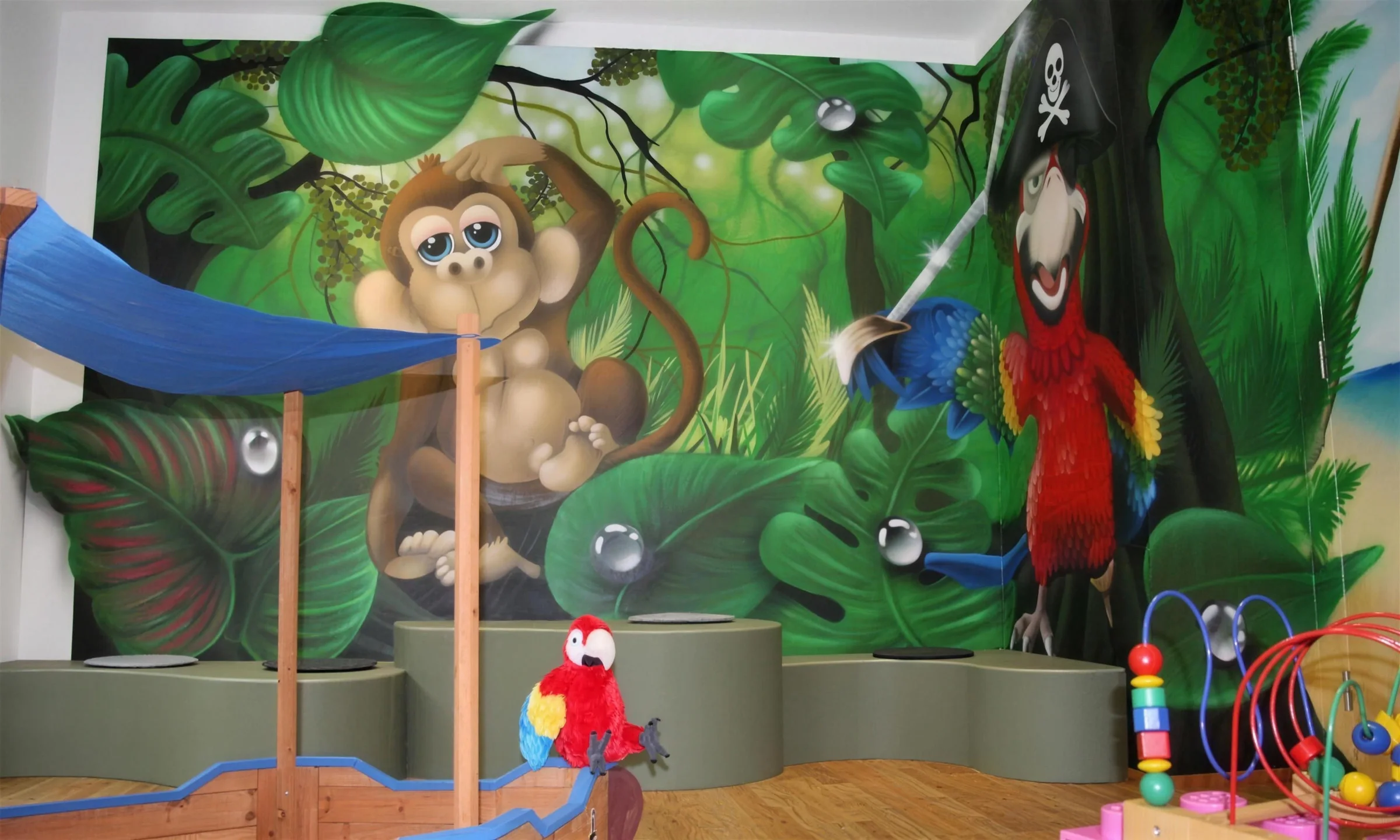 Kinderwartezimmer mit Dschungel-Wandbild, Affe, Papagei und Piratenschiff