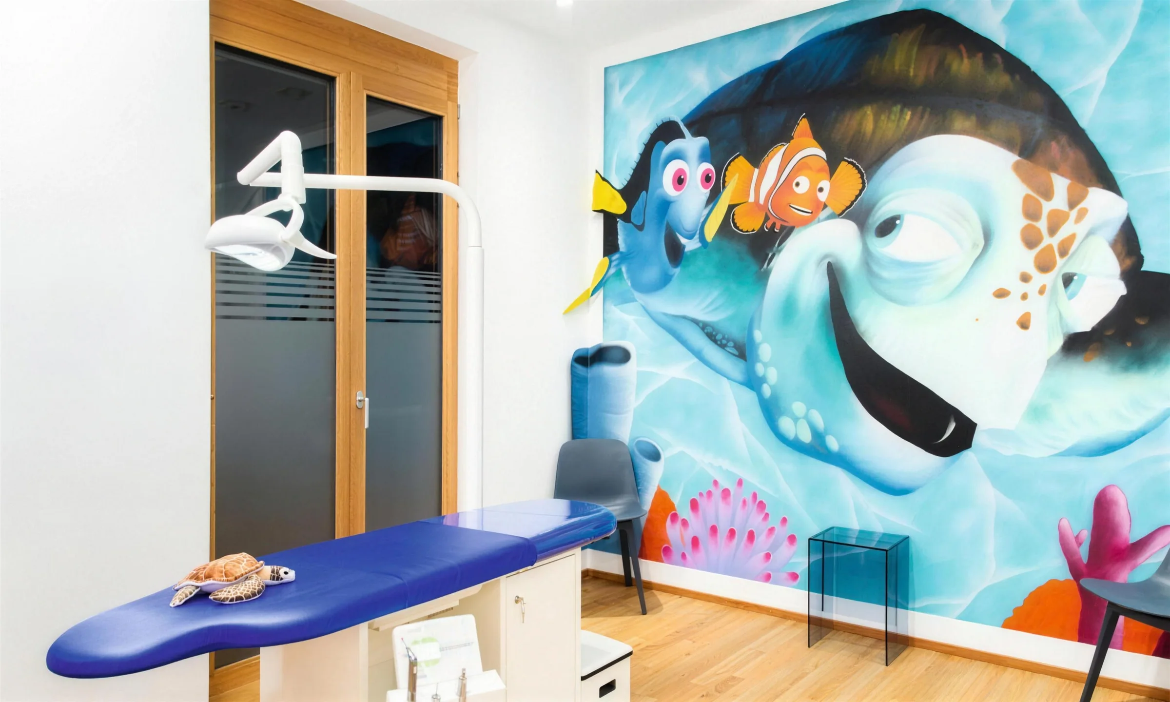 Behandlungszimmer mit Unterwasser-Wandbild und Kinderbehandlungsstuhl